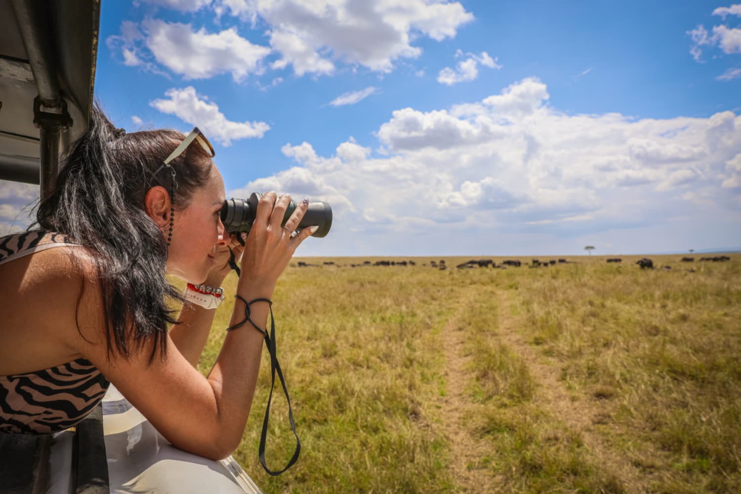 Donna con binocolo durante un safari
